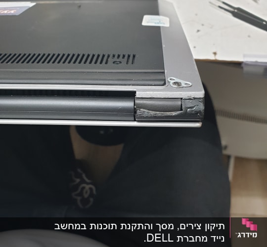מחשב נייד עם פינה שבורה וכלי עבודה על שולחן